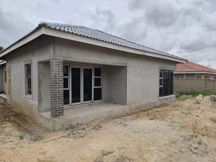 A plastered house with a tiled roof, sliding doors and a face-brick verandah pillar